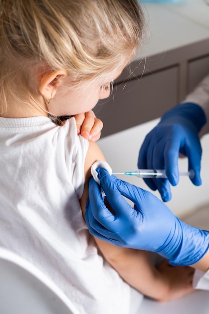 Vaccination des enfants une petite fille lors d'un rendez-vous chez le médecin une injection dans le bras le conce