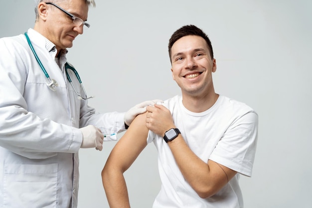 La vaccination est administrée au patient, le médecin en manteau de protection le fait en laboratoire