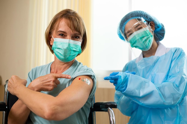 Vaccination des gens. Bonheur femme âgée adulte .personnes après avoir reçu le vaccin Corona Virus pour prévenir les maladies à l'hôpital. Traitement avec injection de soins de santé.