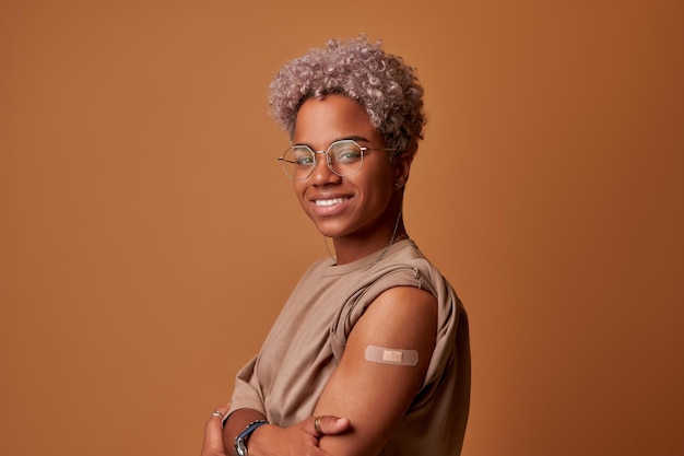 Vacciné covid jeune femme afro-américaine souriante regardant la caméra