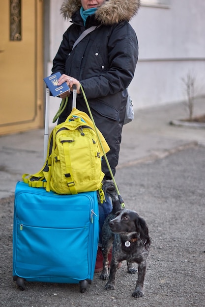 Évacuation de civils enfant triste avec le drapeau de l'Ukraine Famille de réfugiés d'Ukraine traversant la frontière Main tenant un passeport au-dessus des bagages avec le drapeau jaune-bleu Arrêter la guerre soutenir l'Ukraine