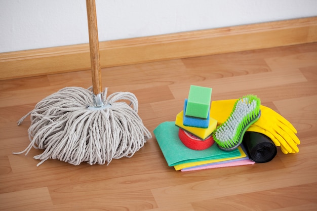 Vadrouille et matériel de nettoyage sur plancher en bois