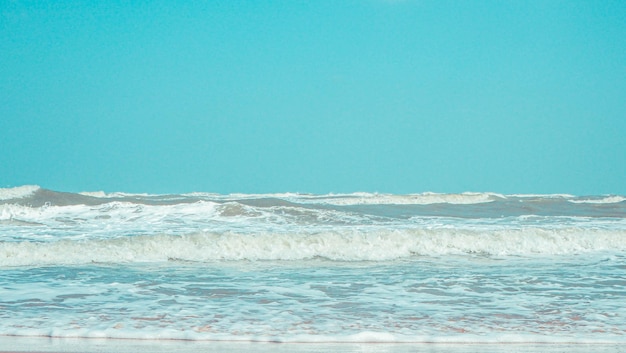 Vague douce avec bulle de l'océan bleu sur le sable blanc à la plage tropicale en été Fond de plage simple pour l'été Bulle bleue vague de la mer au sable sur la plage Fond d'été