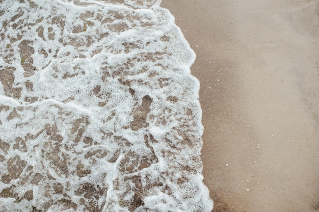 Vague douce de la mer sur la plage de sable