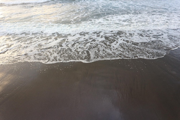 Vague douce de l&#39;océan bleu sur la plage de sable fin. Contexte.