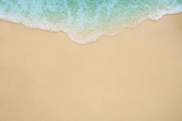 Vague douce de l'océan sur la plage de sable.