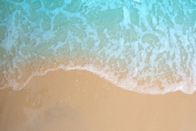 Vague douce de l'océan sur la plage de sable.