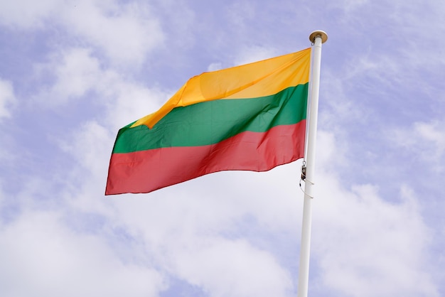 Vague de drapeau lituanien de la Lituanie au-dessus d'un ciel nuageux