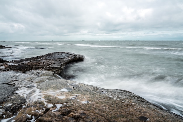 Vague éclaboussant les rochers, longue exposition