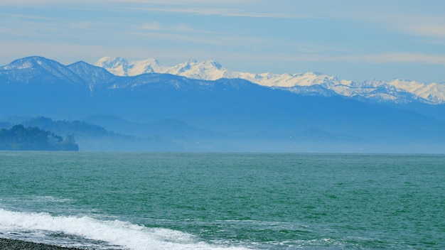 Une vague éclaboussante sur un rivage de pierre sur un lac de montagne un jour des cailloux sur le rivage au ralenti