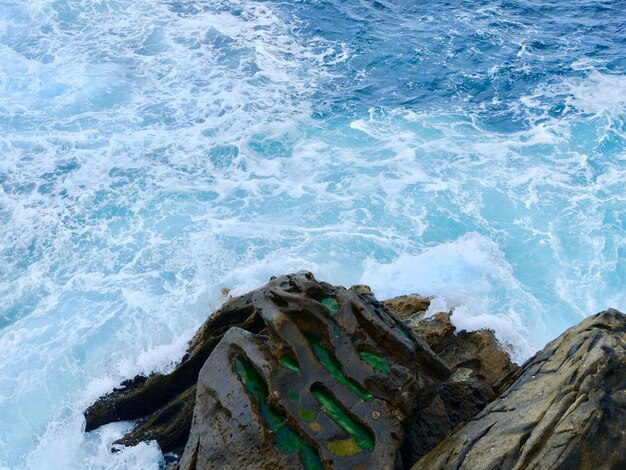 Vague de mer d'un bleu vif éclaboussant de roche au bord de la mer cantabrique pendant la journée Vue aérienne de San Sebastian Pays Basque Espagne