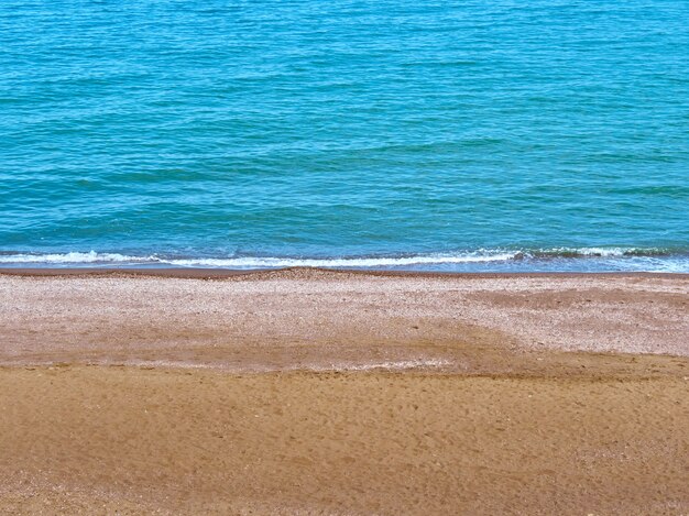 Vague de la mer bleue sur une côte propre avec plage de sable