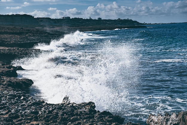 Vague de mer éclaboussant sur les rochers, fond saisonnier de hipster vintage de vacances naturelles. Chypre