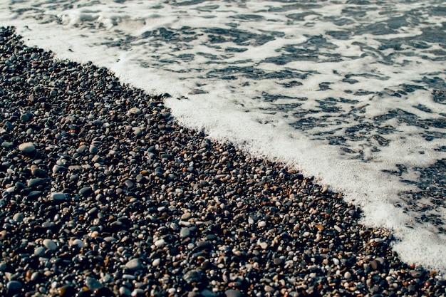 Vague De Mer Avec De La Mousse Sur La Plage De Galets