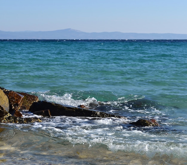 Photo vague de mer et pierres kassandra halkidiki grèce