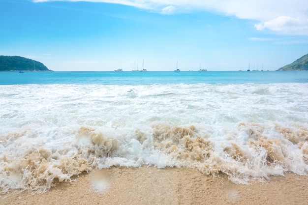 Vague de mer sur la plage de sable sur le ciel bleu