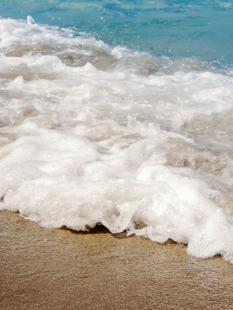 Vague d'océan bleu sur la plage de sable fond d'été