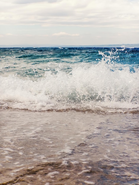 Vague d'océan bleu sur la plage de sable fond d'été