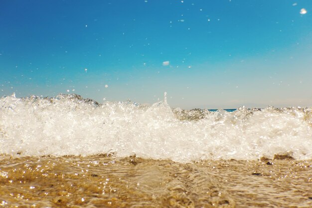 Vague d'océan bleu sur la plage de sable fond d'été