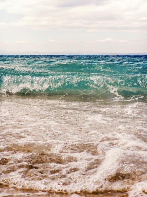 Vague d'océan bleu sur la plage de sable fond d'été