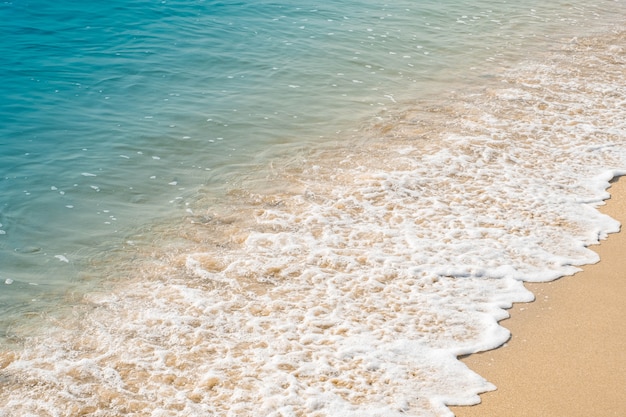 Vague de l'océan bleu sur la plage de sable.