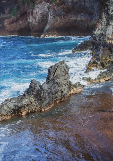 Vague d'océan de fond de mer s'écrasant sur la côte rocheuse avec le jet et la mousse avant la tempête