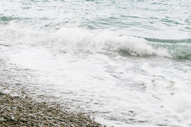 La vague recouvre la plage de galets