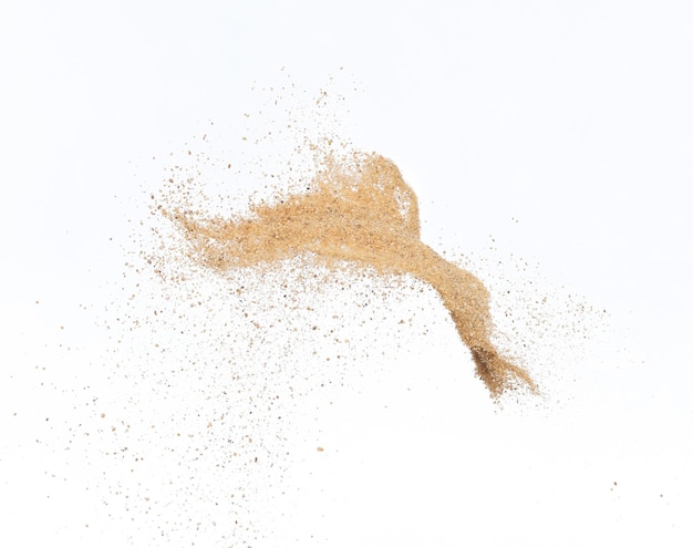 Une vague de sable doré explose Des nuages de sable abstraits volent Des éclaboussures de sable de couleur jaune jetées dans l'air