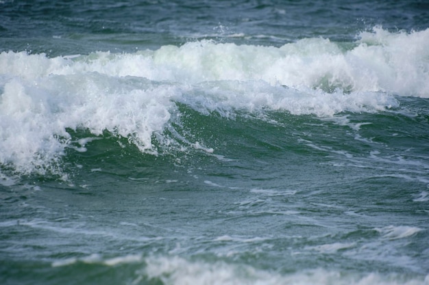 Vague de surf avec éclaboussures de mousse sur la mer