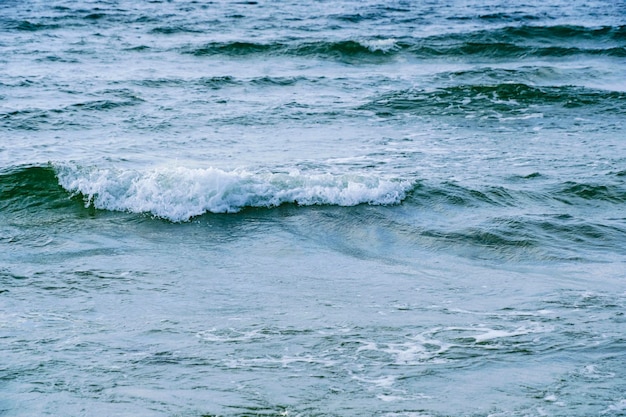 Vague de surf avec éclaboussures de mousse sur la mer