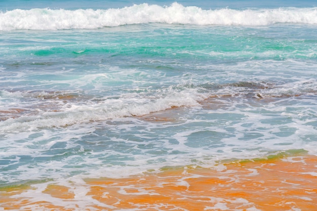 Vagues bleues de l&#39;océan et sable jaune de la plage.