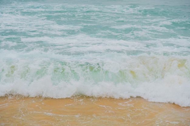 Vagues bleues de l&#39;océan et sable jaune de la plage.