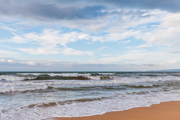 Des vagues calmes sur la plage. La tempête arrive