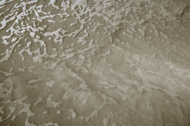 Vagues d'eau sur la plage de sable