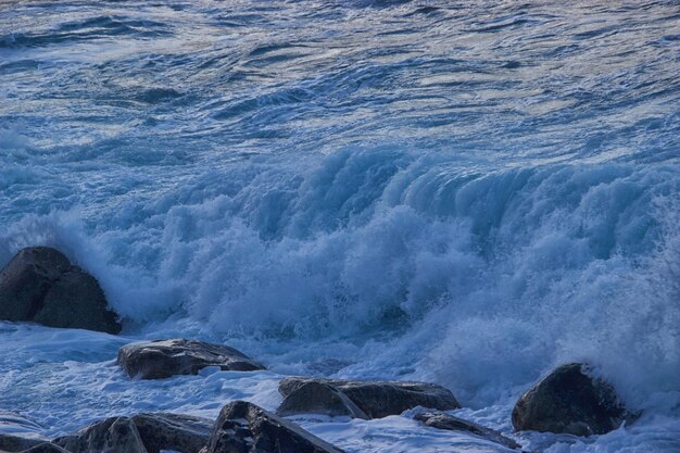 Photo des vagues éclaboussant sur les rochers de la mer