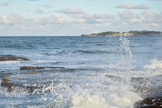 Des vagues avec des éclaboussures frappent le rivage