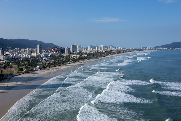 Vagues frappant la plage avec la ville en arrière-plan