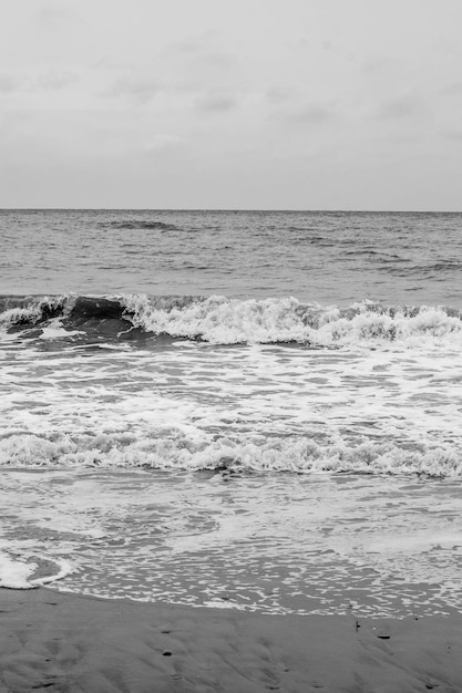 Les vagues de la mer l'eau de mer sur le sable L'atmosphère de la mer et la détenteNoir et blanc