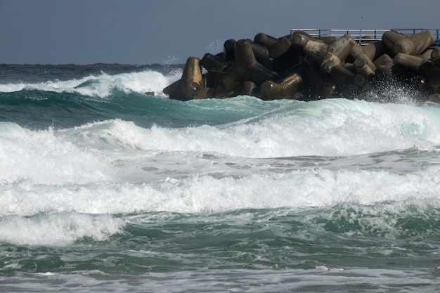 Les vagues de la mer éclaboussant les rochers contre un ciel clair