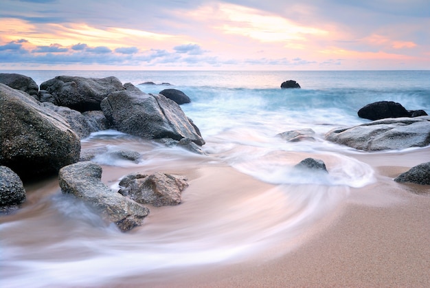 Les vagues de la mer frappent la roche sur la plage