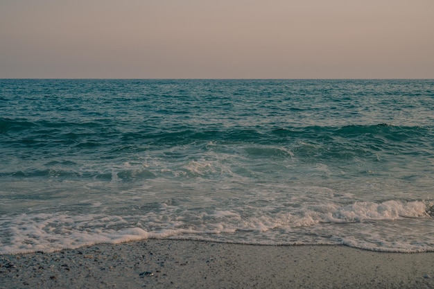 Vagues de la mer Méditerranée roulant jusqu'à la plage de sable turque belle soirée turque