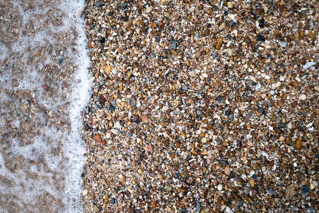 Vagues de la mer sur la plage avec plein de pierres