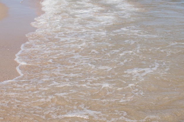 Vagues de la mer sur un rivage sablonneux dans l'après-midi