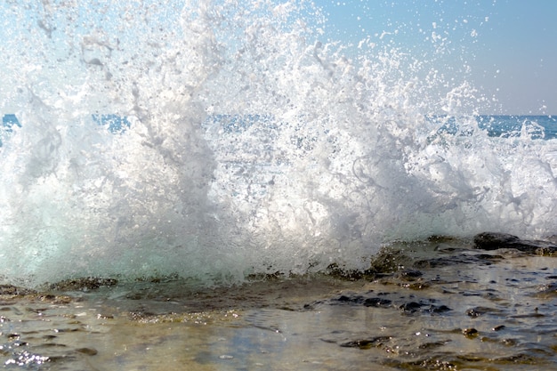 Photo vagues de la mer se brisant sur une plage de galets