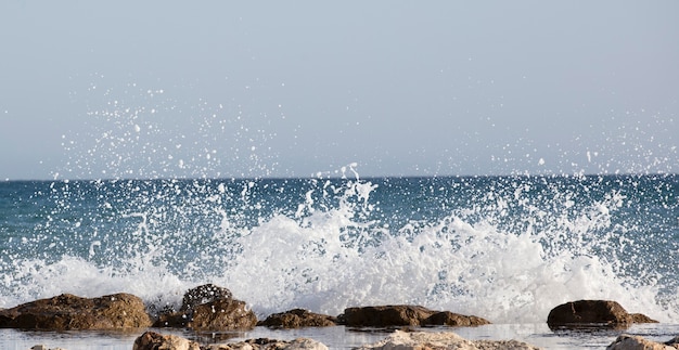 Les vagues de la mer se brisent contre les rochers