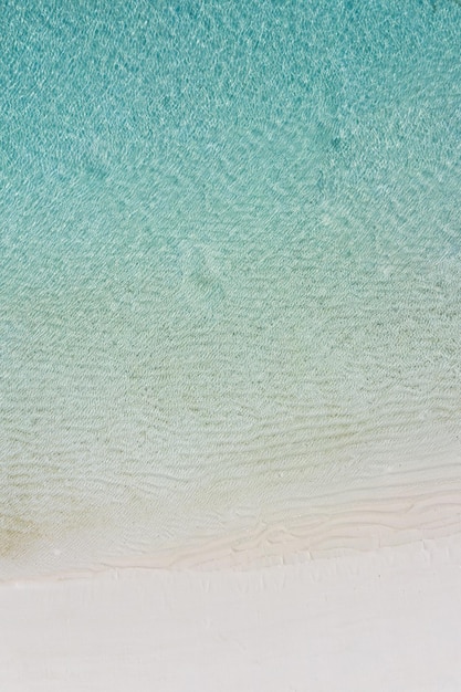 Vagues de l'océan bleu doux sur la plage tropicale, beau paysage aérien. Mer d'été tranquille et relaxante