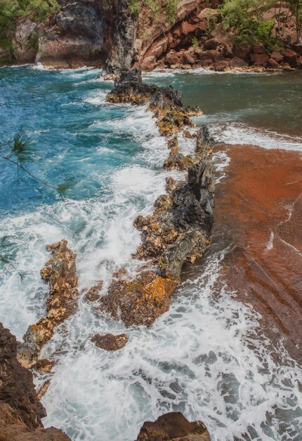 Vagues de l'océan se brisant sur la côte rocheuse de l'île éclaboussant les vagues et les pierres de l'océan