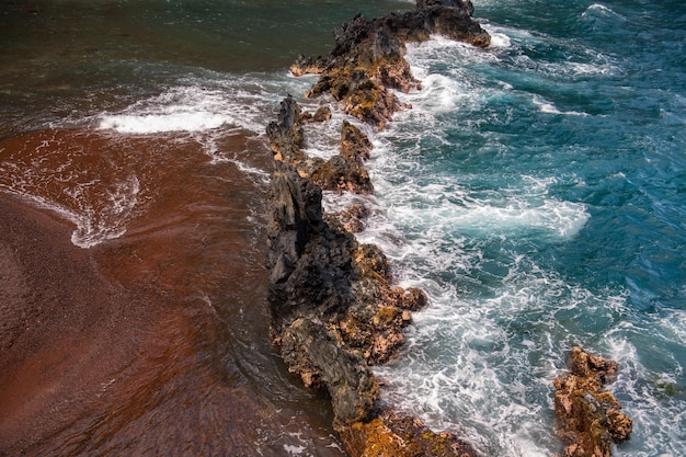 Vagues de l'océan se brisant sur la côte rocheuse de l'île