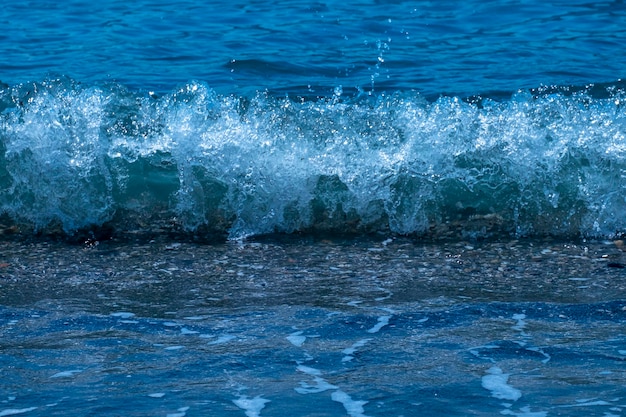 Vagues de l'océan se brisant sur la plage de sable Vagues de la mer se brisant sur le rivage