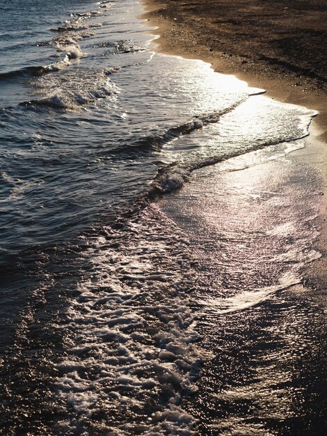 Vagues de la plage et de la mer au coucher du soleil